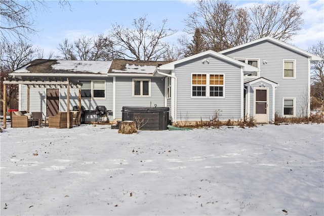 snow covered property with a hot tub and central AC