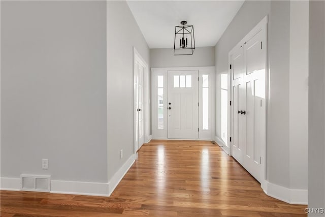 entryway featuring an inviting chandelier and light wood-type flooring