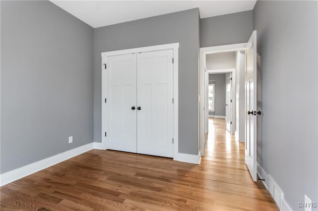 unfurnished bedroom featuring a closet and light hardwood / wood-style flooring