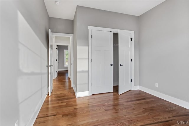 unfurnished bedroom with a closet and hardwood / wood-style flooring