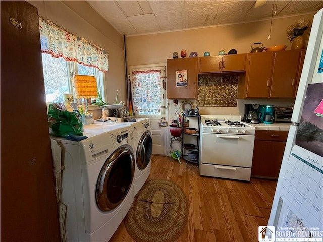 laundry room featuring washing machine and dryer and light hardwood / wood-style floors