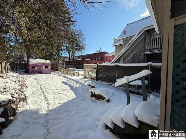 yard covered in snow with a storage shed