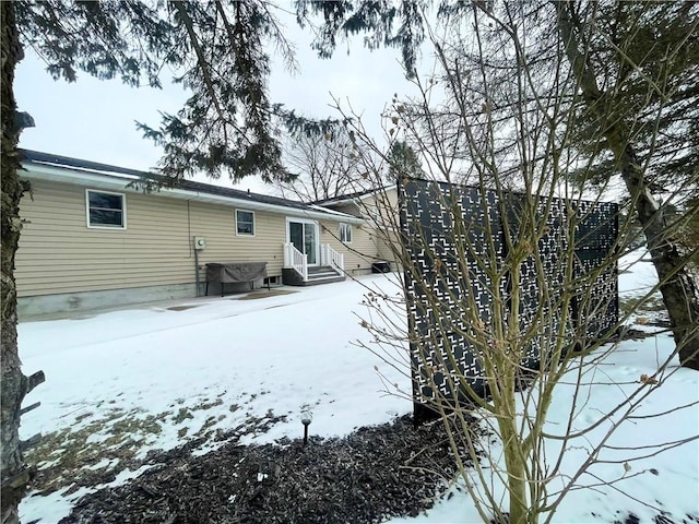 view of snow covered back of property