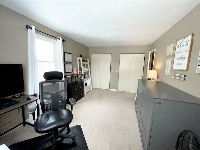 carpeted office featuring a textured ceiling