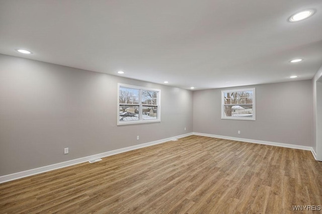 empty room with hardwood / wood-style floors and a healthy amount of sunlight