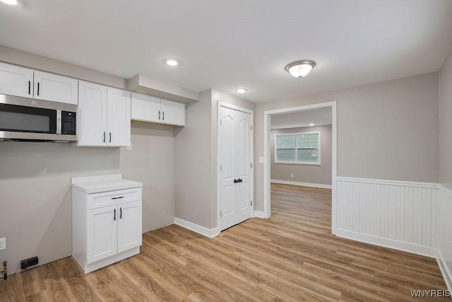 kitchen with white cabinets and light hardwood / wood-style flooring