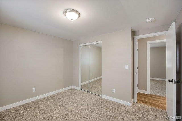 unfurnished bedroom featuring a closet and light carpet