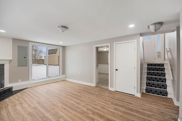 unfurnished living room featuring electric panel and hardwood / wood-style flooring