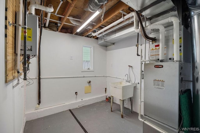 basement featuring sink and heating unit