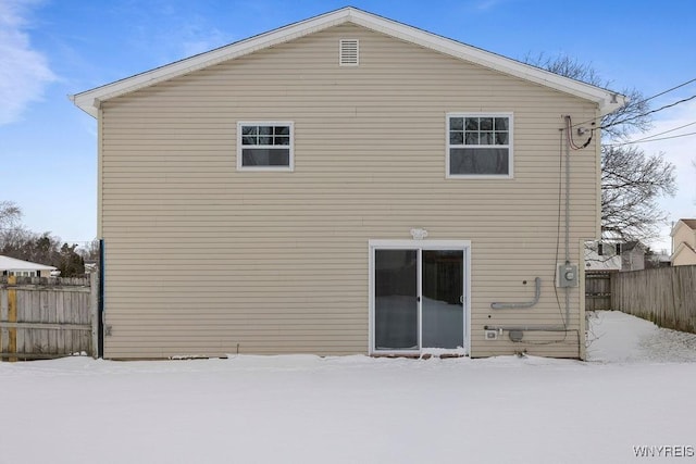 view of snow covered back of property