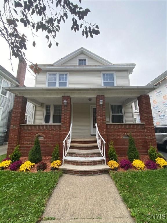 view of front facade with a front yard and covered porch