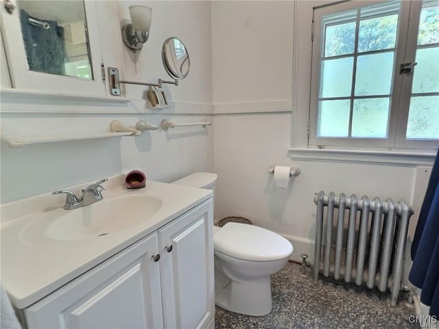 bathroom featuring radiator heating unit, vanity, and toilet