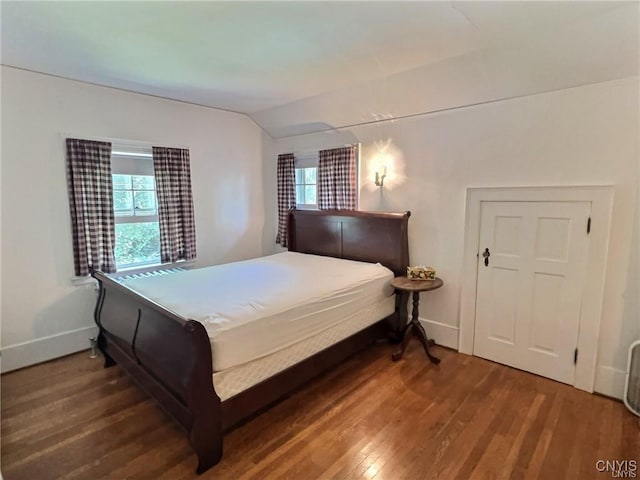 bedroom with dark hardwood / wood-style flooring and lofted ceiling