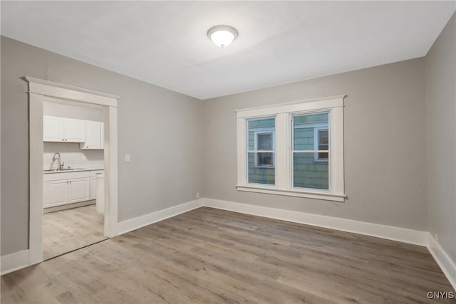 empty room with sink and light wood-type flooring