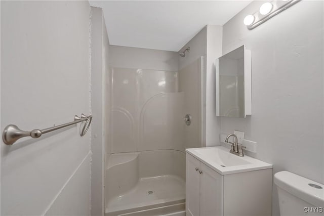 bathroom with toilet, walk in shower, and vanity