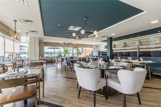 dining room featuring a raised ceiling and an inviting chandelier