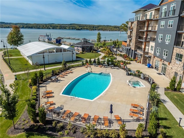 view of pool featuring a patio area and a water view