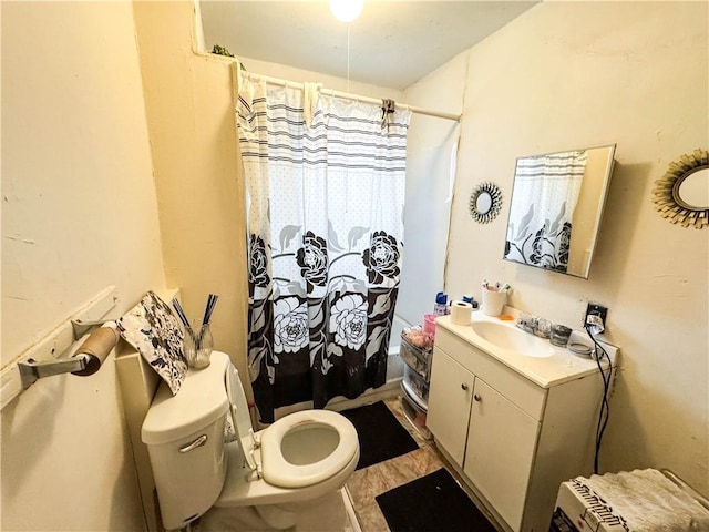 bathroom with walk in shower, vanity, and toilet