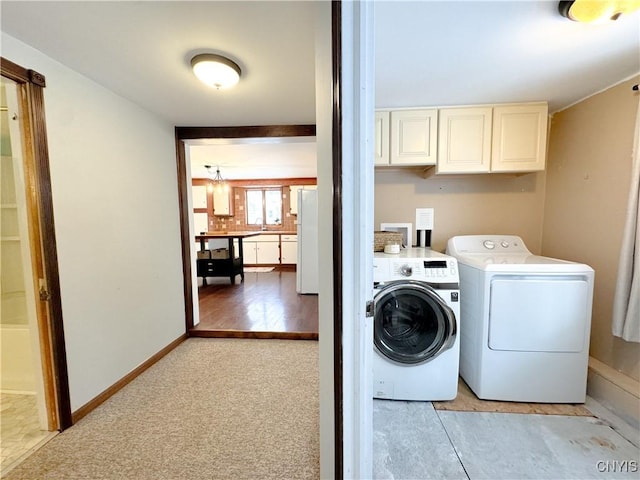 laundry area with light colored carpet, cabinets, and washer and clothes dryer