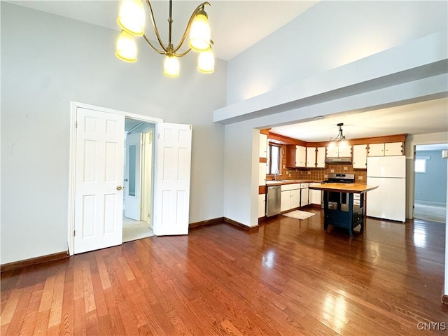 interior space with sink, an inviting chandelier, a towering ceiling, and dark hardwood / wood-style floors