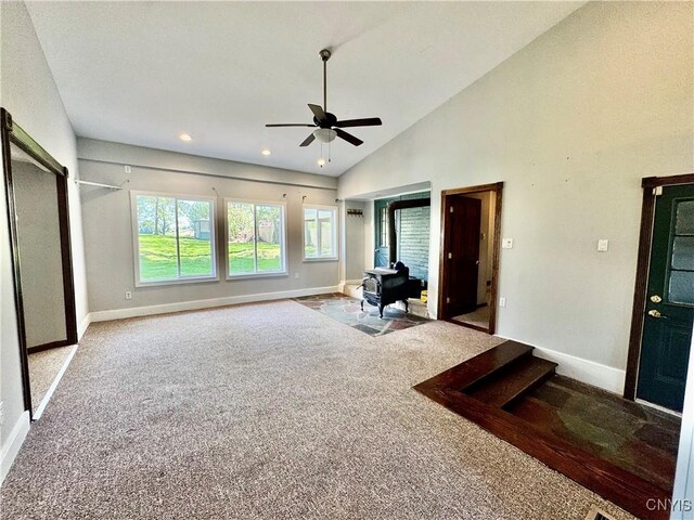 5902 N Rd, Owasco, NY 13021 - carpeted living area with a ceiling fan, baseboards, vaulted ceiling, a wood stove, and recessed lighting
