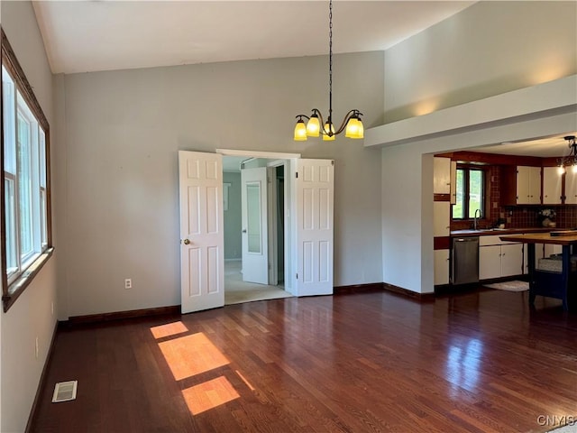 5902 N Rd, Owasco, NY 13021 - unfurnished dining area with a chandelier, dark wood finished floors, baseboards, high vaulted ceiling, and a sink