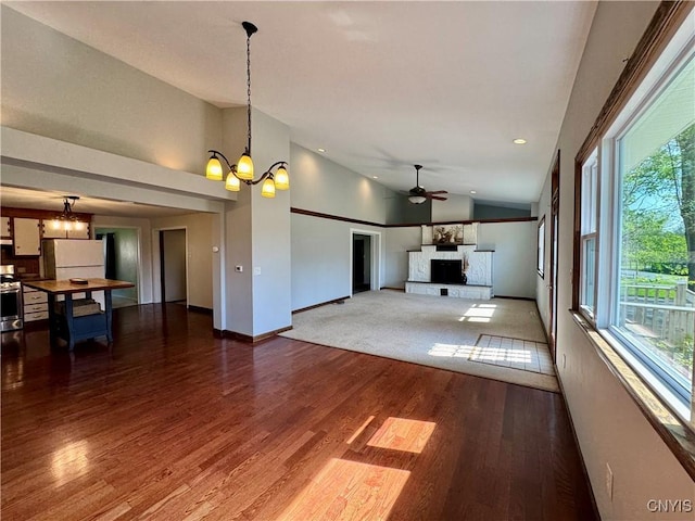 5902 N Rd, Owasco, NY 13021 - unfurnished living room with a chandelier, lofted ceiling, ceiling fan, baseboards, and wood finished floors