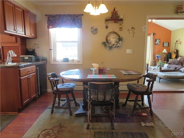 dining area with sink, dark wood-type flooring, a notable chandelier, and lofted ceiling