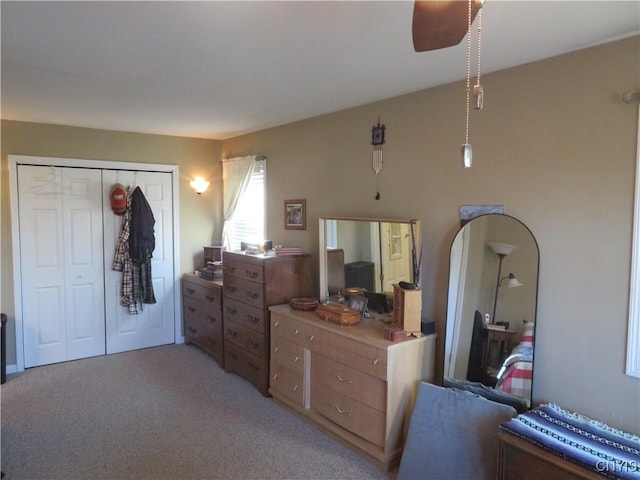 carpeted bedroom with ceiling fan and a closet