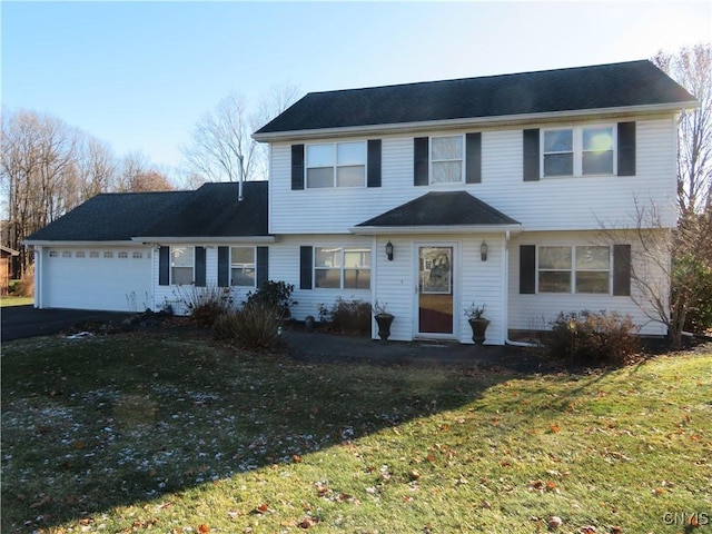 view of property featuring a front yard and a garage