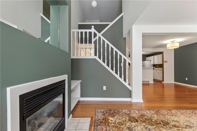 staircase featuring hardwood / wood-style floors and a fireplace