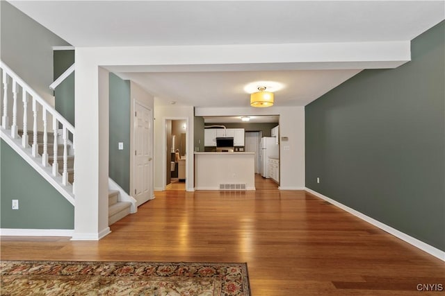 unfurnished living room with wood-type flooring