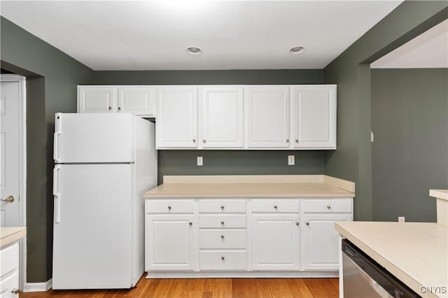 kitchen with white refrigerator, stainless steel dishwasher, and white cabinetry