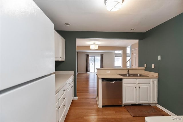 kitchen featuring stainless steel dishwasher, light wood-type flooring, white cabinetry, white refrigerator, and sink