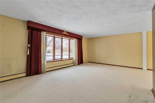 carpeted empty room featuring baseboard heating