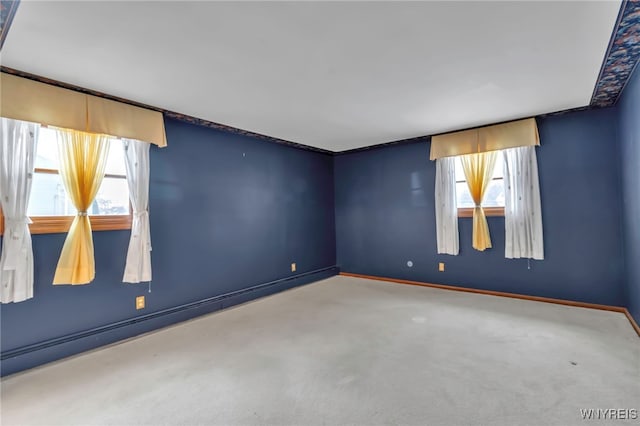 carpeted empty room with a wealth of natural light and a baseboard radiator