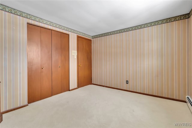 unfurnished bedroom featuring light colored carpet and baseboard heating