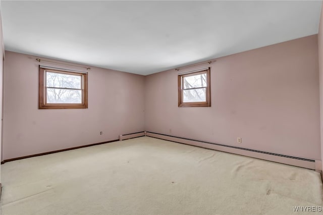 unfurnished room featuring light carpet, plenty of natural light, and a baseboard radiator