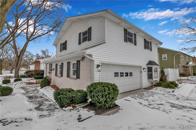 snow covered property featuring a garage