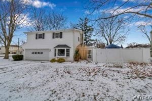 snow covered house with a garage