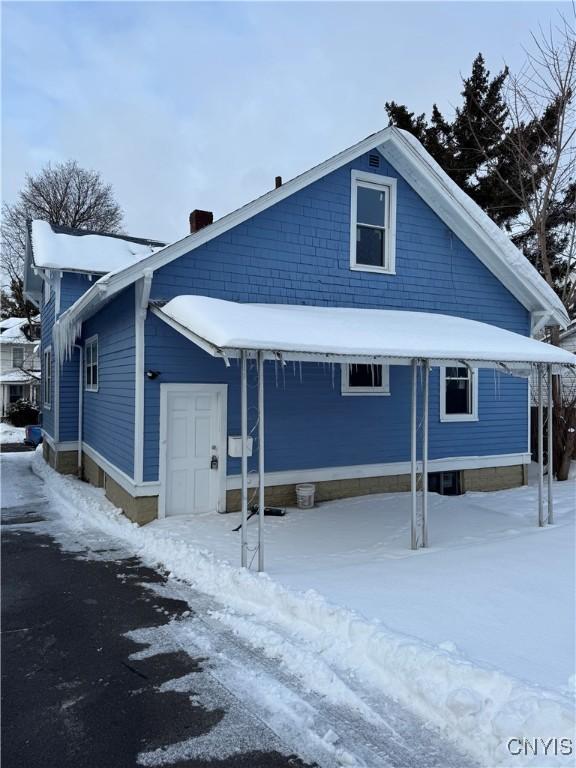 view of snow covered back of property