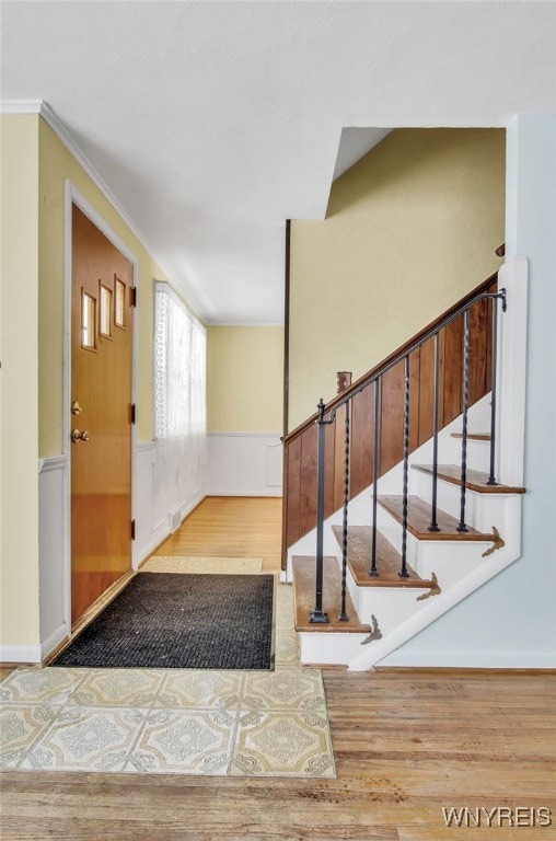 foyer featuring wood-type flooring and ornamental molding