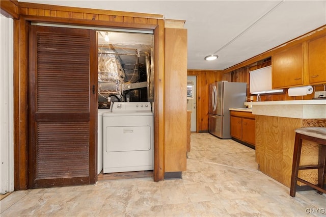 washroom featuring washer / dryer and wooden walls