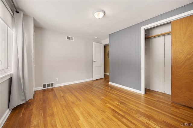 unfurnished bedroom with a closet and hardwood / wood-style flooring