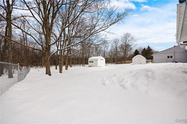 yard layered in snow featuring a storage unit