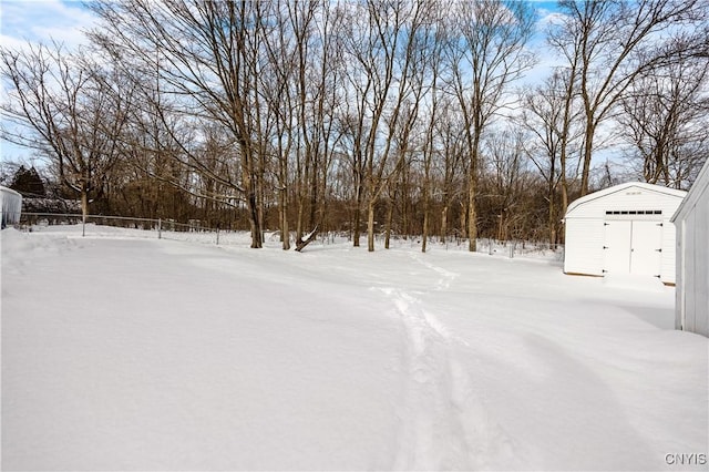 yard layered in snow featuring a storage unit