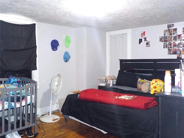 bedroom with hardwood / wood-style floors and a textured ceiling