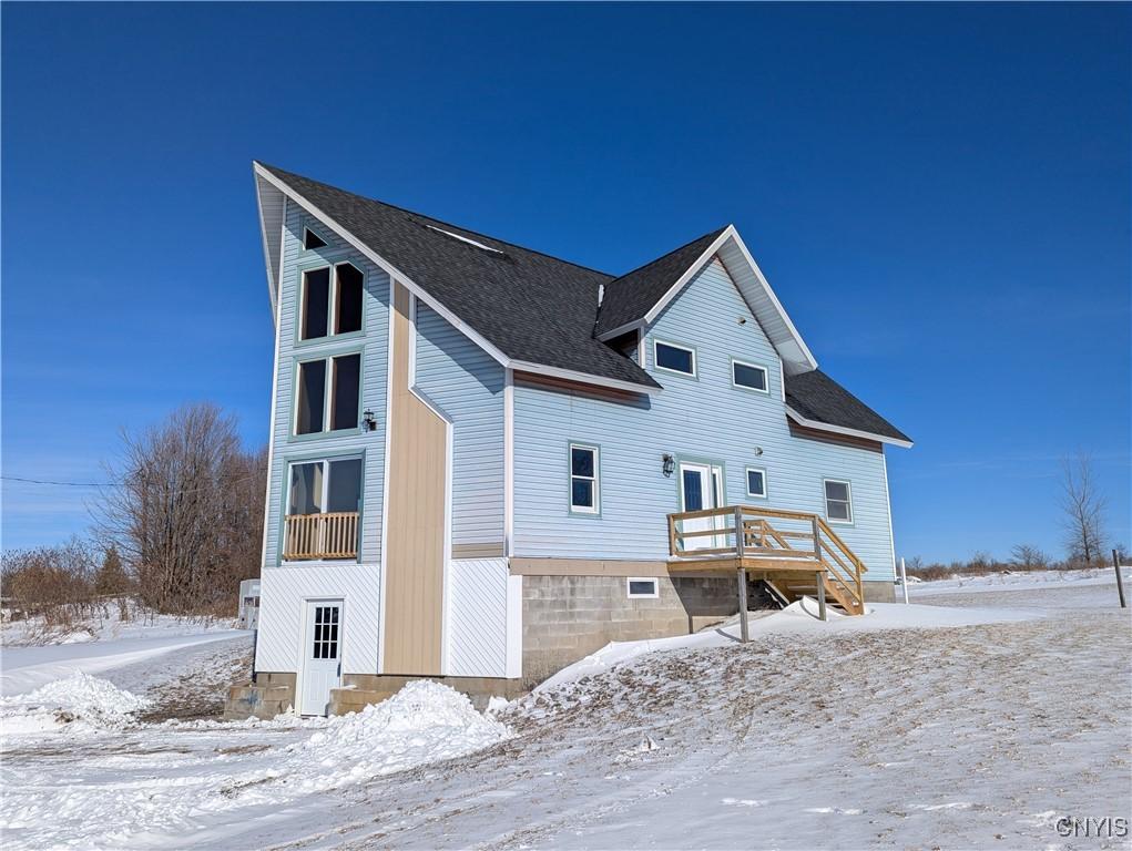 snow covered house with a wooden deck