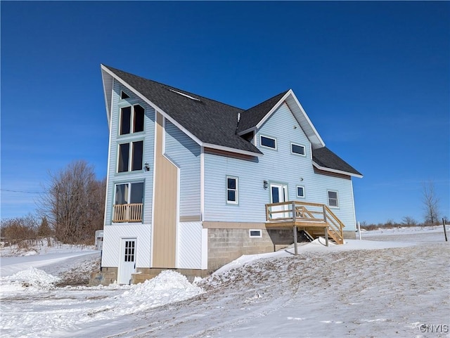 snow covered house with a wooden deck