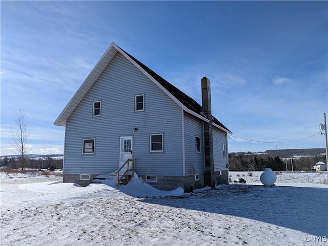 view of snow covered rear of property